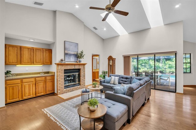 10 Greenhaven Cir, Oldsmar, FL 34677 - living room featuring high vaulted ceiling, ceiling fan, light wood finished floors, healthy amount of natural light, and a skylight