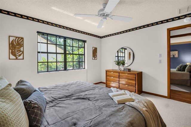 10 Greenhaven Cir, Oldsmar, FL 34677 - carpeted bedroom with baseboards, a textured ceiling, and ceiling fan
