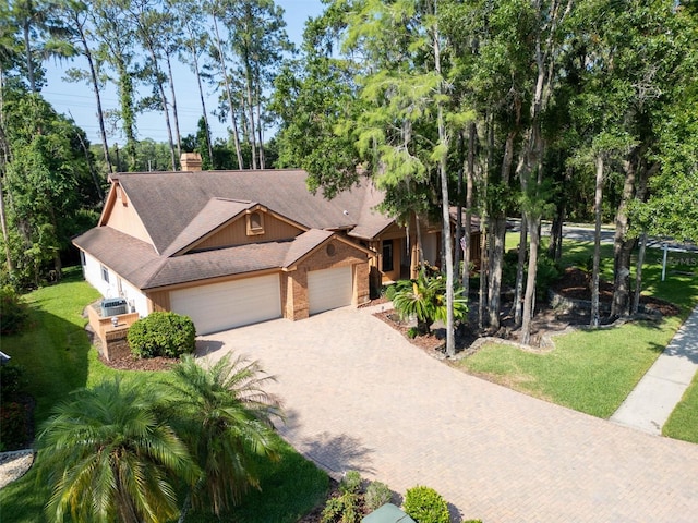 10 Greenhaven Cir, Oldsmar, FL 34677 - view of front facade with an attached garage, decorative driveway, brick siding, a front lawn, and a shingled roof