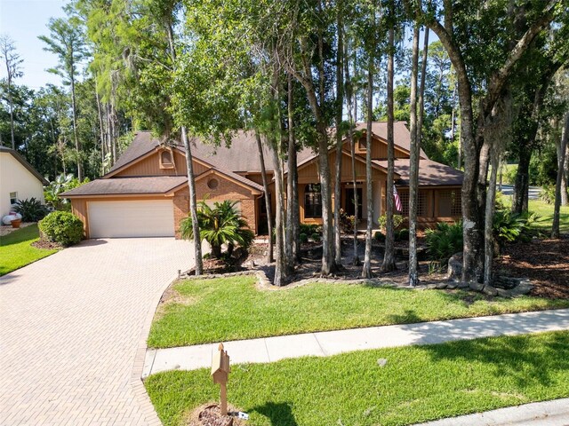 10 Greenhaven Cir, Oldsmar, FL 34677 - view of front of house featuring decorative driveway, an attached garage, a front lawn, and a shingled roof