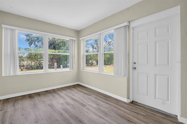 unfurnished room with baseboards and wood finished floors