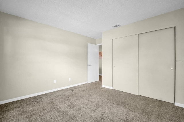 unfurnished bedroom featuring carpet flooring, a closet, baseboards, and a textured ceiling