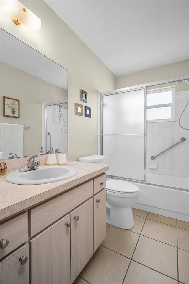 full bathroom featuring tile patterned floors, vanity, toilet, and shower / bath combination with glass door