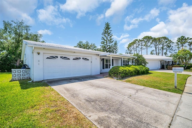 single story home featuring a front lawn, a garage, concrete driveway, and stucco siding