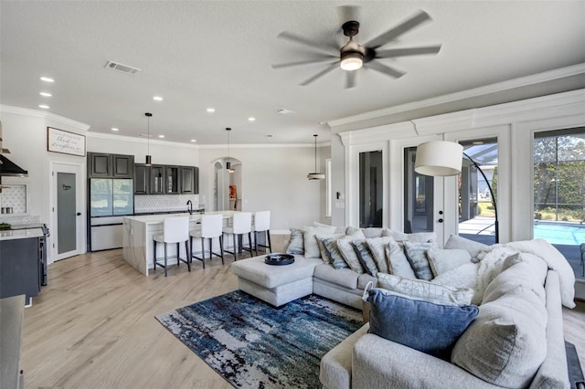 655 Whisper Woods Dr, Lakeland, FL 33813 - living room with ornamental molding, light wood finished floors, and a ceiling fan