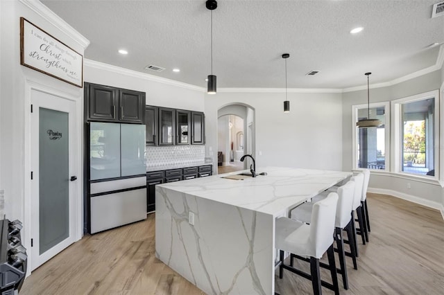 655 Whisper Woods Dr, Lakeland, FL 33813 - kitchen with refrigerator, arched walkways, a sink, and visible vents