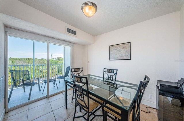 dining space featuring a textured ceiling, visible vents, and baseboards