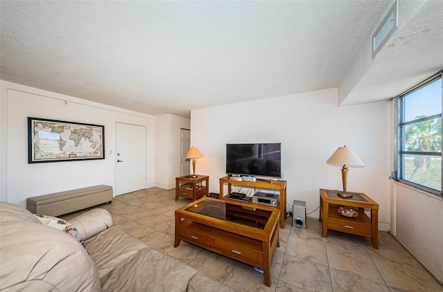 living area with a textured ceiling and visible vents