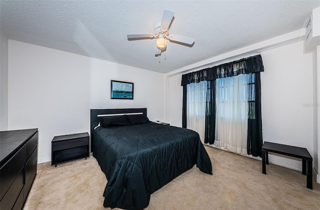 bedroom with light colored carpet, a textured ceiling, and ceiling fan