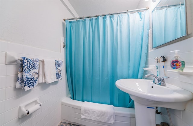 full bath with tile walls and shower / bath combination with curtain