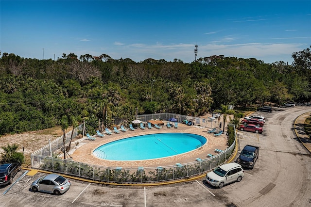 community pool featuring fence and a forest view