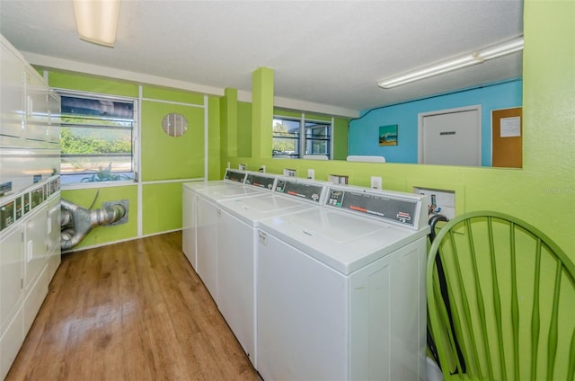 common laundry area featuring independent washer and dryer, a wealth of natural light, and light wood-style floors