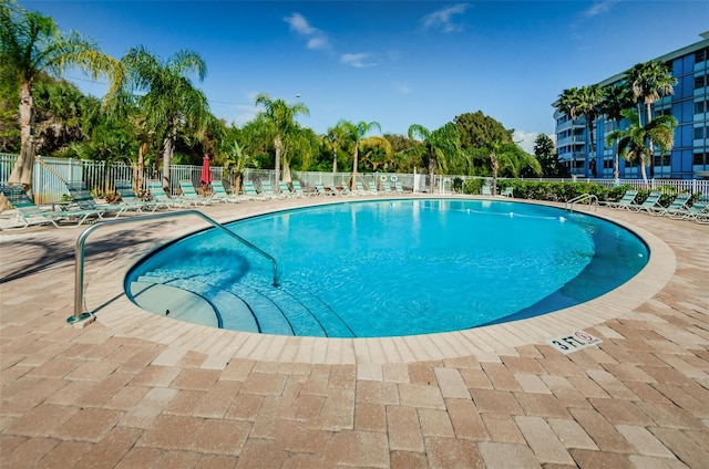 community pool with fence and a patio