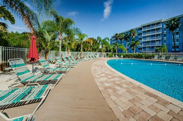 community pool with fence and a patio area