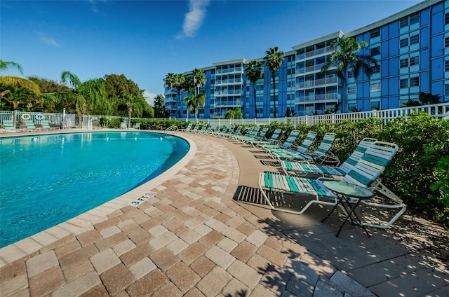 community pool with fence and a patio