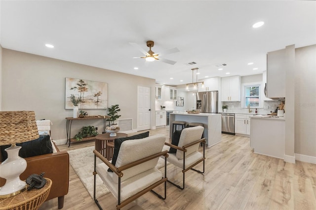 7494 7th St N, Saint Petersburg, FL 33702 - living area with light wood-style floors, a ceiling fan, baseboards, and recessed lighting