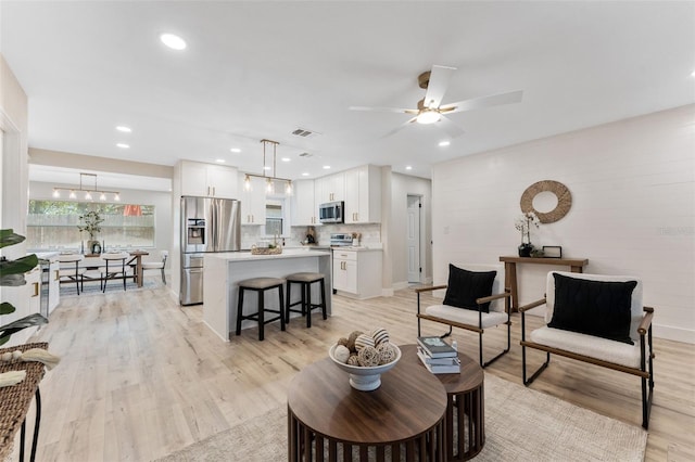 7494 7th St N, Saint Petersburg, FL 33702 - living room featuring recessed lighting, ceiling fan, visible vents, and light wood-style flooring