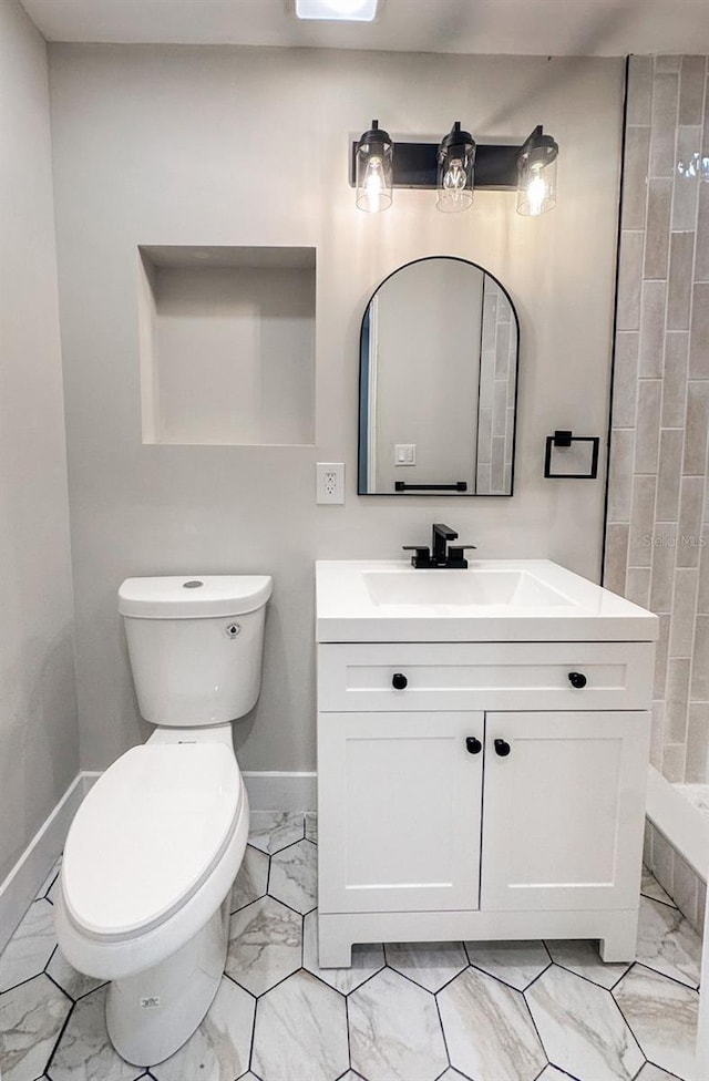 7494 7th St N, Saint Petersburg, FL 33702 - bathroom with vanity, marble finish floor, toilet, baseboards, and tiled shower