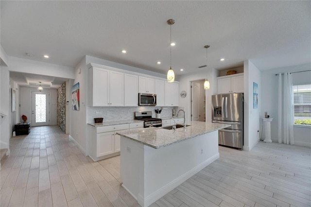 5814 Silver Sun Dr, Apollo Beach, FL 33572 - kitchen with stainless steel appliances, a sink, light wood-style flooring, tasteful backsplash, and recessed lighting