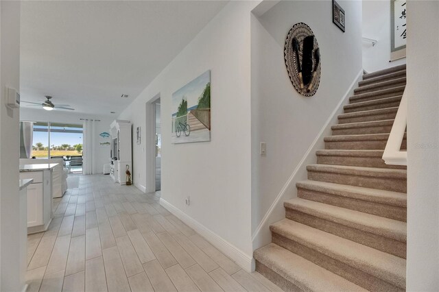 5814 Silver Sun Dr, Apollo Beach, FL 33572 - hallway with stairs, baseboards, and light wood-style flooring