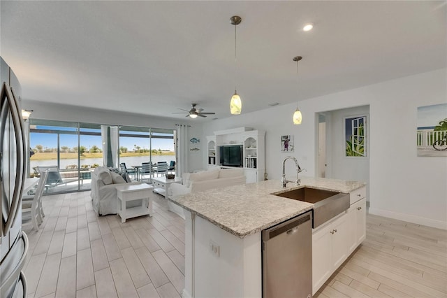 5814 Silver Sun Dr, Apollo Beach, FL 33572 - kitchen with appliances with stainless steel finishes, a sink, light wood finished floors, ceiling fan, and decorative light fixtures