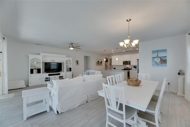5814 Silver Sun Dr, Apollo Beach, FL 33572 - dining space featuring ceiling fan, a chandelier, light wood-style floors, and baseboards
