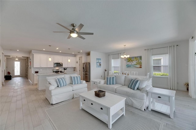 5814 Silver Sun Dr, Apollo Beach, FL 33572 - living area featuring a chandelier, a ceiling fan, recessed lighting, baseboards, and light wood finished floors