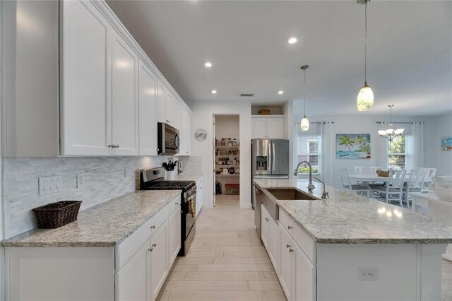 5814 Silver Sun Dr, Apollo Beach, FL 33572 - kitchen featuring appliances with stainless steel finishes, a sink, backsplash, a center island with sink, and recessed lighting