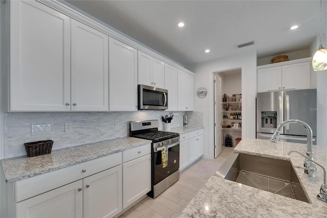 5814 Silver Sun Dr, Apollo Beach, FL 33572 - kitchen with appliances with stainless steel finishes, a sink, tasteful backsplash, white cabinets, and recessed lighting