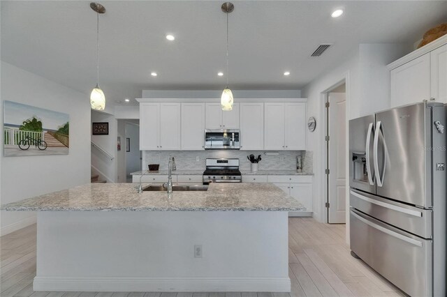 5814 Silver Sun Dr, Apollo Beach, FL 33572 - kitchen featuring stainless steel appliances, a sink, backsplash, white cabinets, and recessed lighting