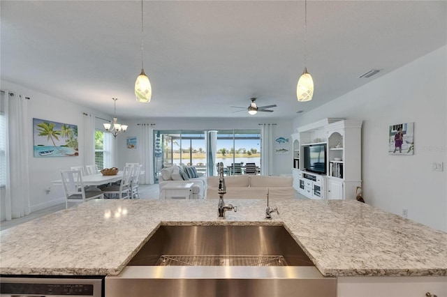 5814 Silver Sun Dr, Apollo Beach, FL 33572 - kitchen featuring a sink, open floor plan, a chandelier, light stone countertops, and ceiling fan