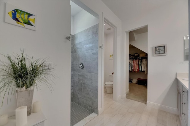 5814 Silver Sun Dr, Apollo Beach, FL 33572 - bathroom with a walk in shower, vanity, toilet, a walk in closet, and baseboards