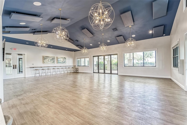 5814 Silver Sun Dr, Apollo Beach, FL 33572 - unfurnished living room featuring a chandelier, high vaulted ceiling, wood finished floors, baseboards, and recessed lighting