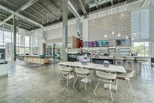 5814 Silver Sun Dr, Apollo Beach, FL 33572 - dining room featuring a towering ceiling, finished concrete flooring, and plenty of natural light