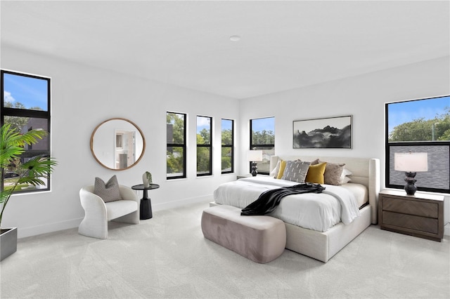carpeted bedroom featuring baseboards and multiple windows