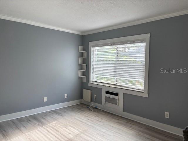4127 Dolphin Dr Unit 4127, Tampa, FL 33617 - unfurnished room with crown molding, a textured ceiling, baseboards, and wood finished floors