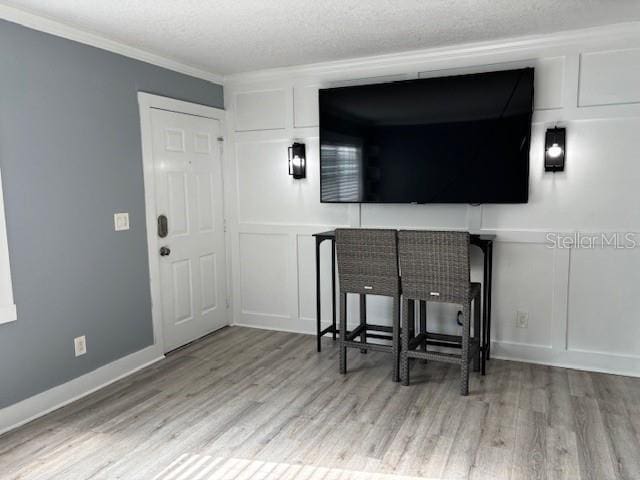 4127 Dolphin Dr Unit 4127, Tampa, FL 33617 - interior space with wood finished floors, a textured ceiling, crown molding, and a decorative wall