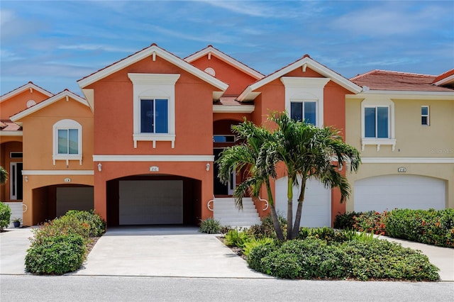 view of front of house featuring stucco siding, a garage, and driveway