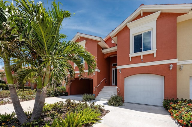 townhome / multi-family property with stucco siding, an attached garage, and concrete driveway