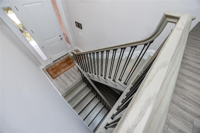 stairway with wood finished floors and baseboards