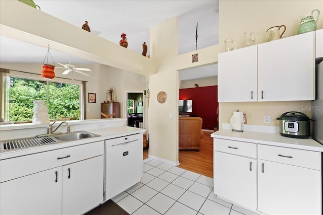7235 Sharpsburg Blvd, New Port Richey, FL 34653 - kitchen featuring white cabinets, white dishwasher, light tile patterned flooring, a sink, and light countertops
