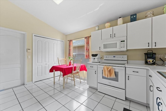 7235 Sharpsburg Blvd, New Port Richey, FL 34653 - kitchen featuring white appliances, light countertops, white cabinetry, light tile patterned floors, and vaulted ceiling