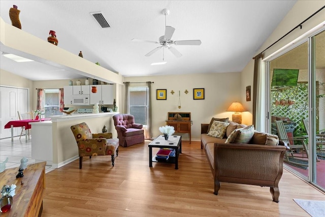 7235 Sharpsburg Blvd, New Port Richey, FL 34653 - living room featuring visible vents, lofted ceiling, a healthy amount of sunlight, and light wood finished floors