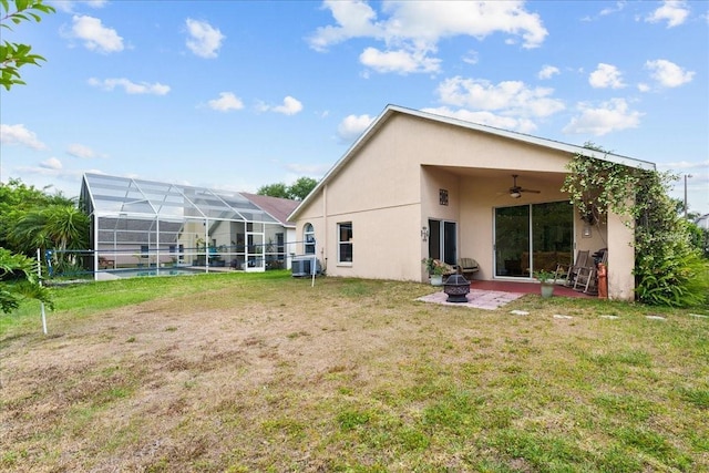 7235 Sharpsburg Blvd, New Port Richey, FL 34653 - rear view of property featuring stucco siding, a yard, a fire pit, and ceiling fan
