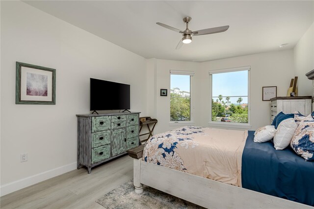 bedroom featuring baseboards, a ceiling fan, and light wood-type flooring