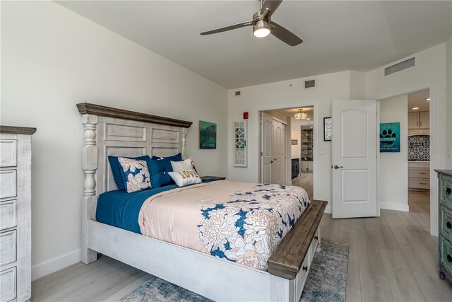 bedroom featuring visible vents, light wood-style floors, and baseboards
