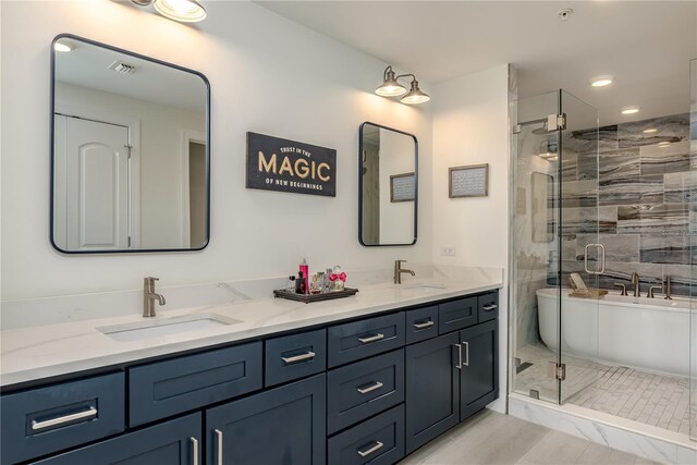 full bathroom featuring double vanity, visible vents, a shower stall, and a sink