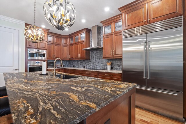 1432 Gopher Loop, Tarpon Springs, FL 34689 - kitchen with stainless steel appliances, wall chimney exhaust hood, a sink, a chandelier, and decorative backsplash