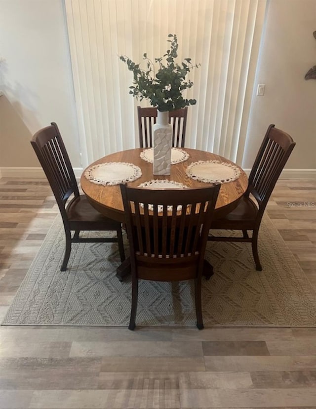 dining room featuring baseboards and wood finished floors