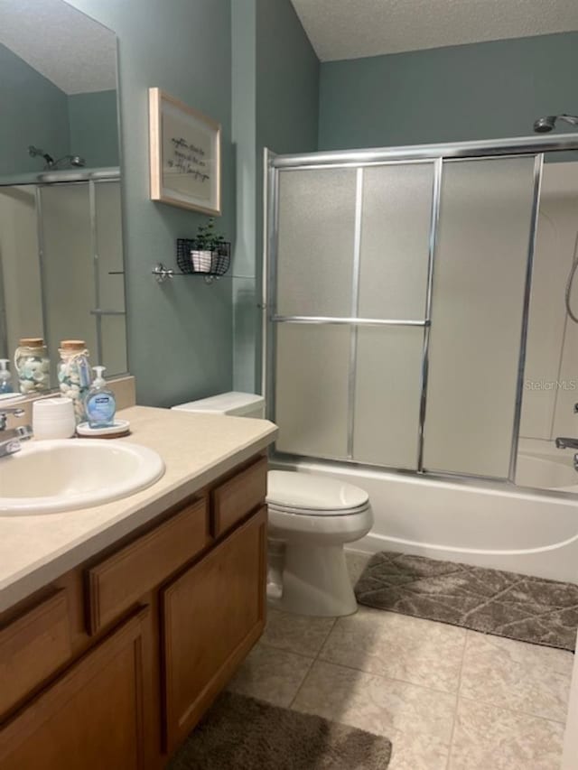 bathroom with shower / bath combination with glass door, vanity, toilet, a textured ceiling, and tile patterned floors